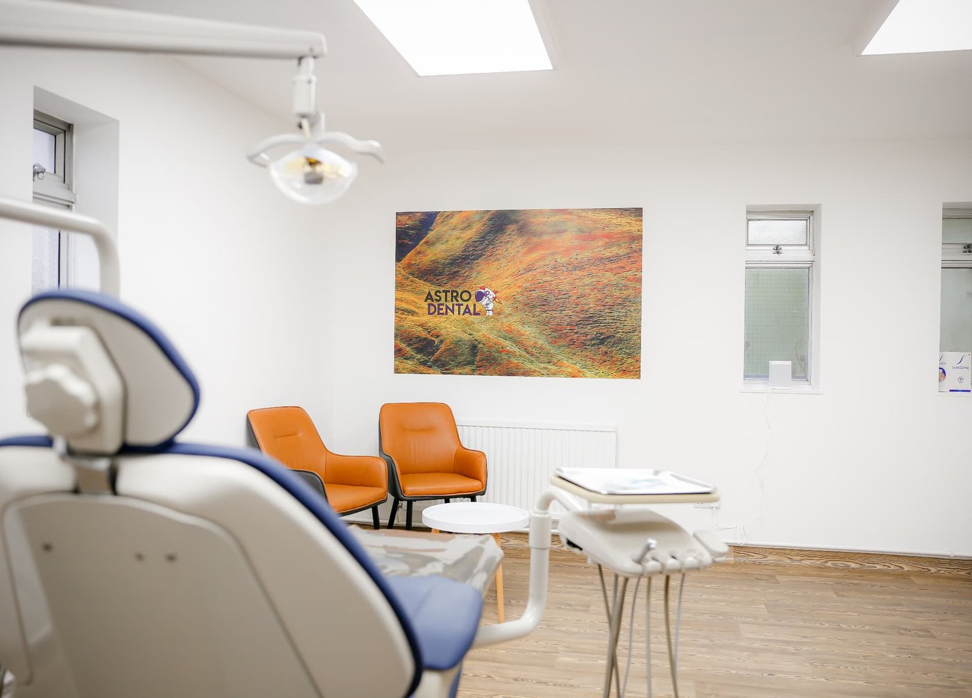 A dental surgery with orange artwork on the wall at Astro Dental